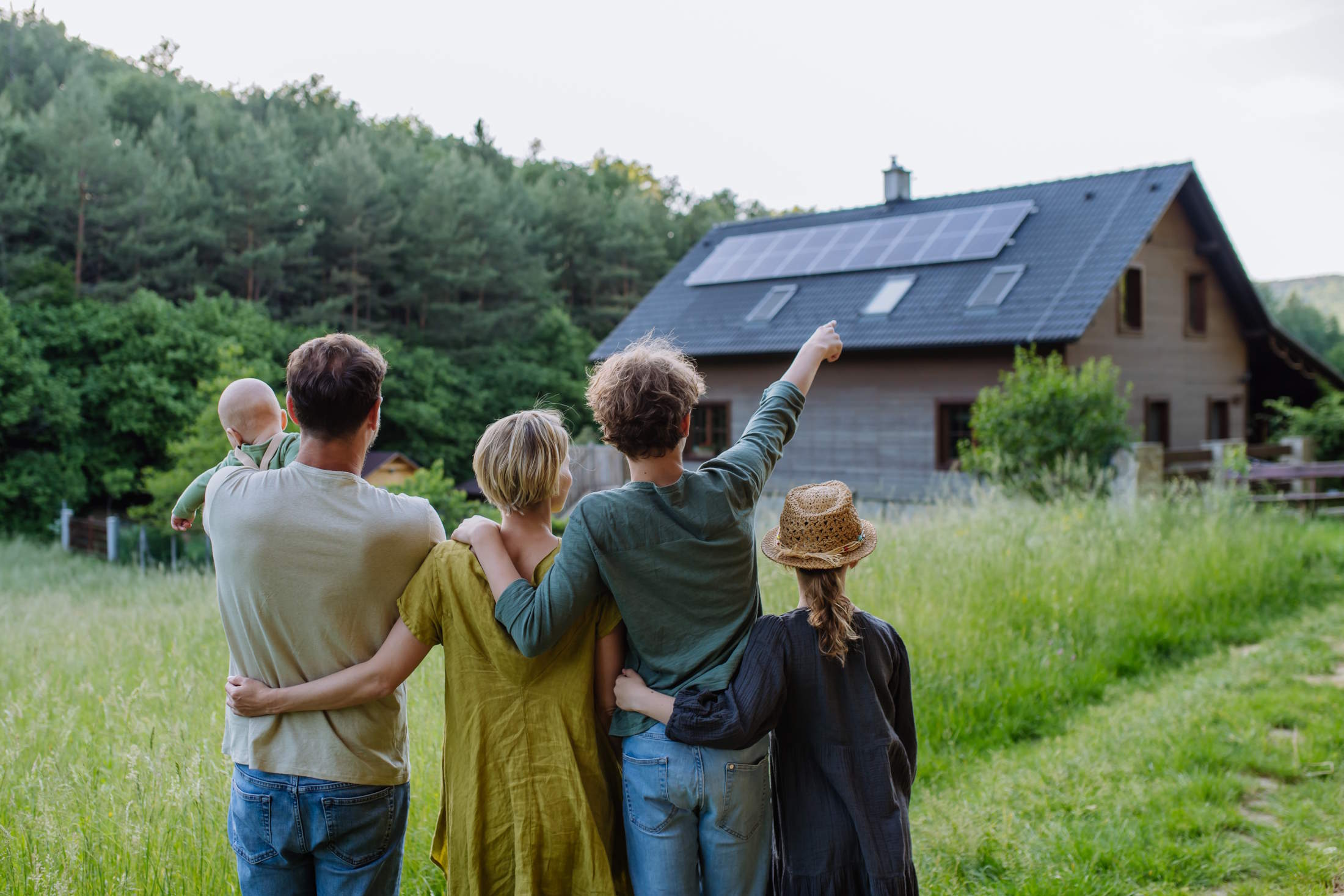 rear view of family near their house with solar pa 2024 10 18 15 00 30 utc